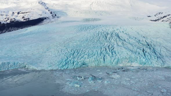 Drone Over Glacier Amongst Snow Covered Mountains