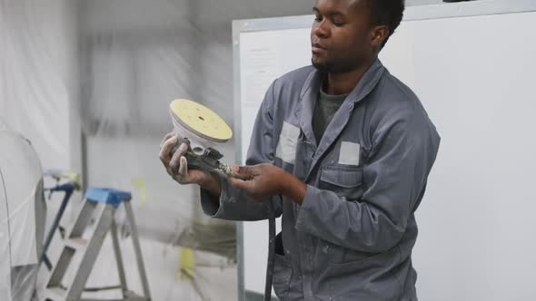 African American male car mechanic working and checking and connecting a tool