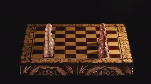 Placement of carved wooden chess pieces on the board alt