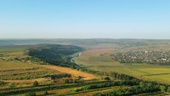 Aerial drone view of a village in Moldova. Valley with river, hills and fields in Moldova