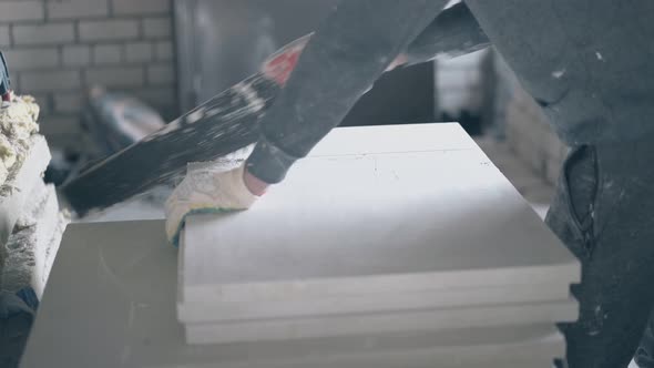 Repairman Holds Saw and Starts Cutting Gypsum Board on Table