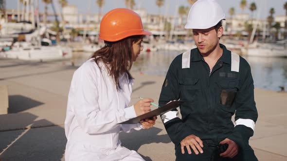 Marine Inspectors Discussing Condition of Boat on Land