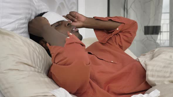 AfroAmerican Man with Patch on Head Pills and Thermometer