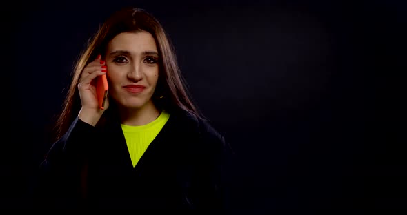 Carefree Joyful Woman Is Talking By Mobile Phone Indoors, Smiling, Medium Portrait in Studio