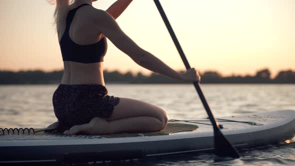 Woman Meditating Pose Sup Board On Vacation.Cross-Legged No Stress Leisure Surfing Boat Fitness.