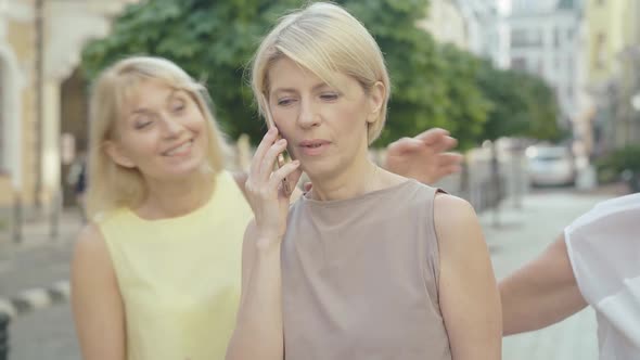 Portrait of Stylish Mid-adult Woman Talking on the Phone As Friends Coming. Happy Female Caucasian