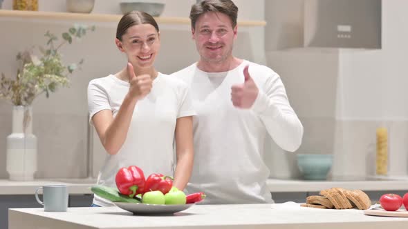 Mixed Race Couple Showing Thumbs Up Sign in Kitchen