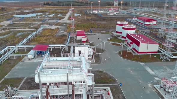 The Drone Flies Over Industrial Buildings Pipelines and Storage Tanks for Oil and Gas