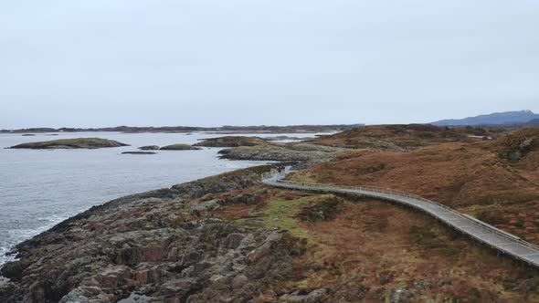 People Walking On Pathway At The Edge Of A Cliff At Atlantic Ocean Road In Norway. Aerial Drone