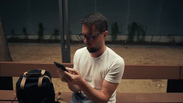 Closeup of a Guy with Smartphone at Night Outside.