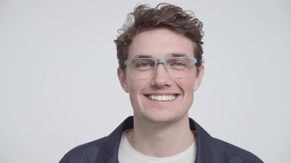 Portrait of a Young Man with Gray Glasses in White Background