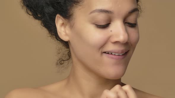Beauty Portrait of Young African American Woman Smears Face Care Cream on Tip of Her Nose and Smiles