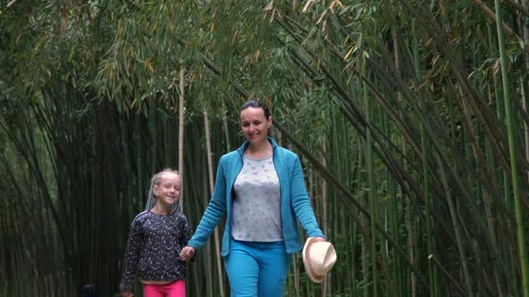 Mother with Daughter Walking in a Bamboo Alley