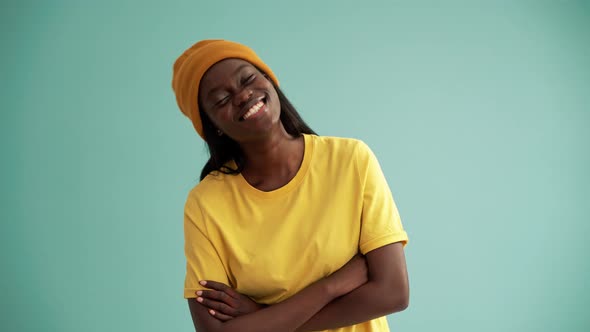 Laughing African woman holding hands and looking at the camera