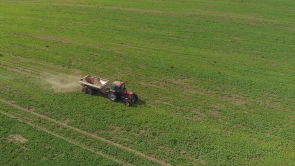 Tractor Spreads Mineral Fertilizers on a Field of Farmland