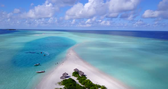 Daytime overhead clean view of a sunshine white sandy paradise beach and blue water background in 4K