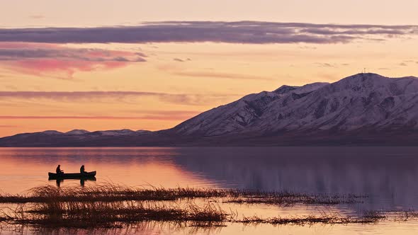 People floating in a canoe during sunset over Utah Lake