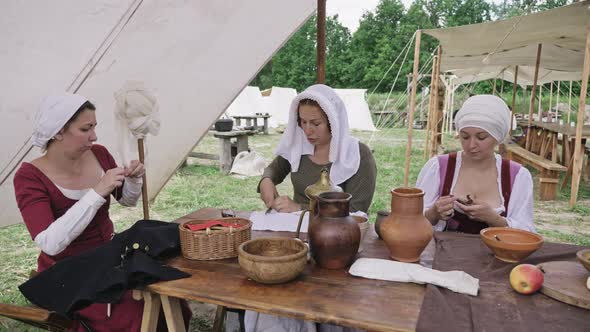 Group of People Dressed in Medieval Clothes Spending Time Together During Sitting at the Table.