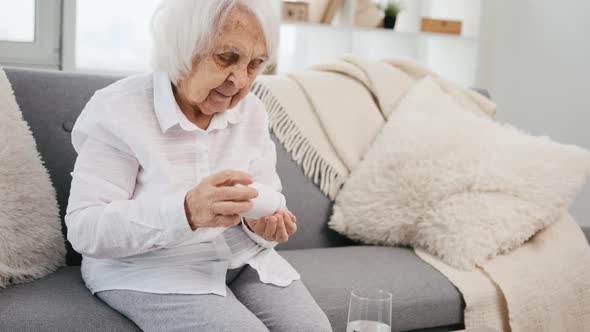 Elderly Woman Takes Pills