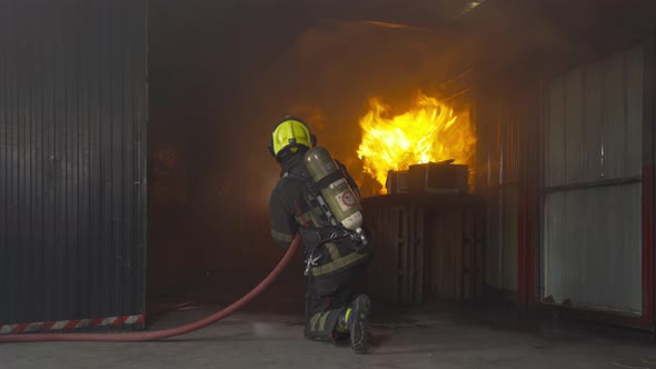 A group of firefighter or fireman with uniform using water fire hose against hot burning fire