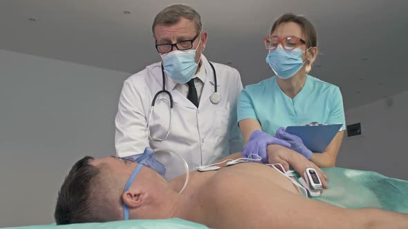 Doctors Examining a Patient on Bed in the Emergency Room of the Hospital