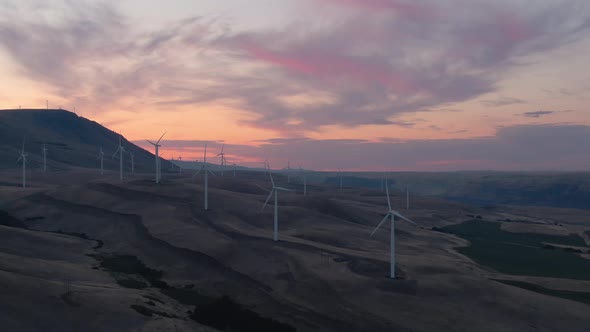 Beautiful Aerial Landscape View of Wind Turbines on a Windy Hill during a colorful sunrise. Taken in