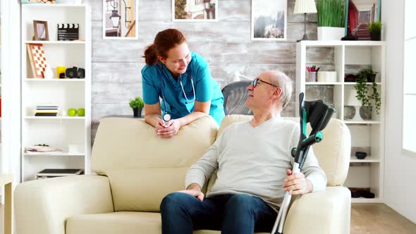 Retired Man in Nursing Home Talking with a Nurse