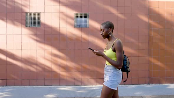 Slow motion shot of young woman using smartphone in city