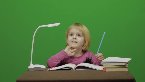 Girl Drawing at the Table. Education Process in Classroom. Chroma Key