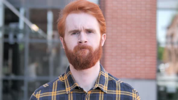 Outdoor Portrait of Upset Redhead Beard Young Man