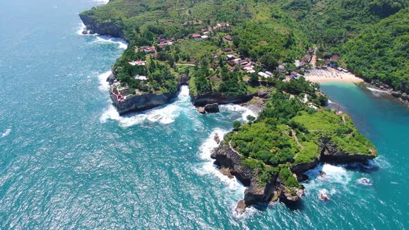 Aerial view of coastal village on cliff and tropical Gesing beach Java Indonesia