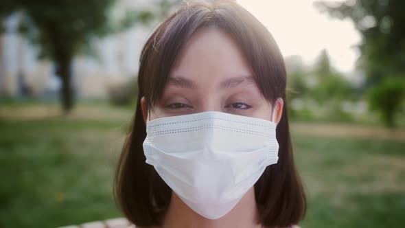 Portrait of Nicelooking Asian Multirace Young Woman in Medical Mask Looking Into Camera and Smiling