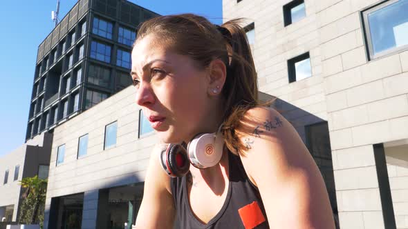 Sporty young woman with leg prosthesis and headphones during break