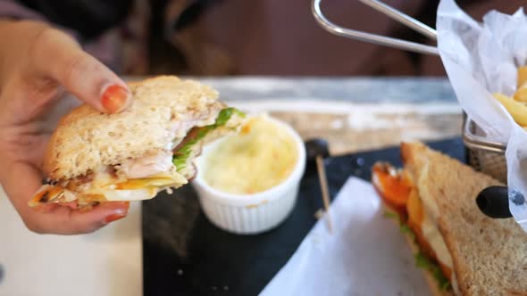 Holding Slice of Half Eaten Chicken Sandwich at Cafe