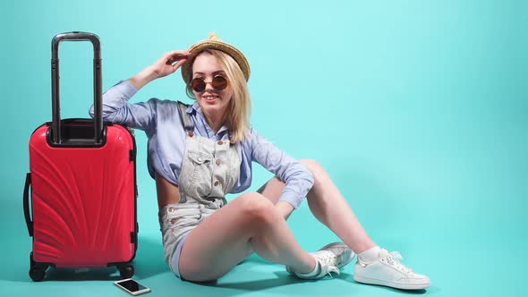 Beautiful Girl with a Red Suitcase Smiles and Looks at Camera. Girl Is Going on a Trip.