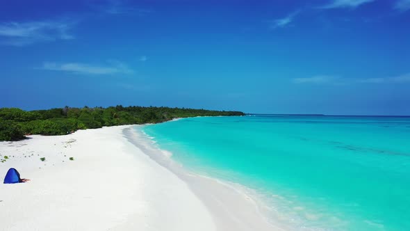 Tropical fly over copy space shot of a sandy white paradise beach and blue water background in color