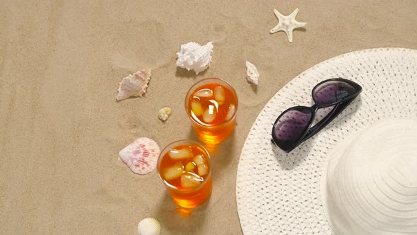 Cocktails, Sun Hat and Sunglasses on Beach Sand