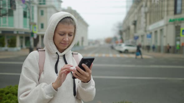 Portrait Of Woman Typing By Mobile Phone Outdoors