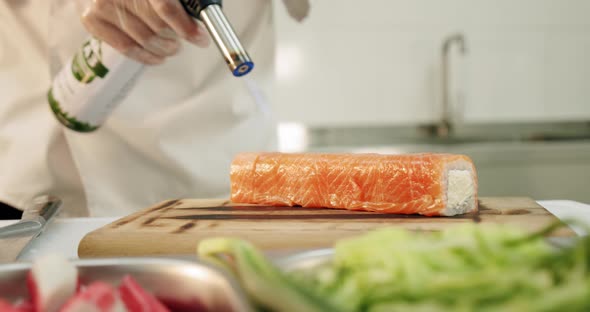 Restaurant Kitchen. Male Sushi Chef Prepares Japanese Sushi Rolls of Rice, Salmon, Avocado and Nori