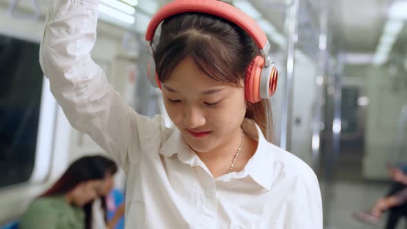 Young Woman Using Mobile Phone on Public Train