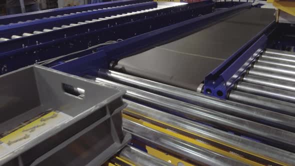 An Empty Plastic Box Moves Along a Roller Conveyor