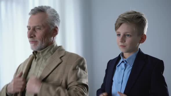 Cute Grandfather and Grandson Putting Jackets On, Preparing for Walk Together