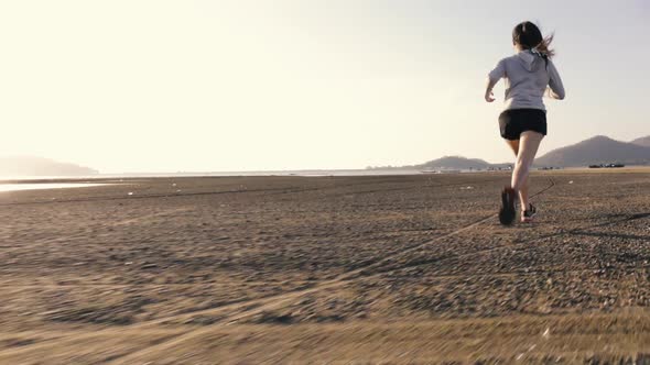 Attractive Asian sport athlete runner woman workout at sunset beach in fitness and healthy.