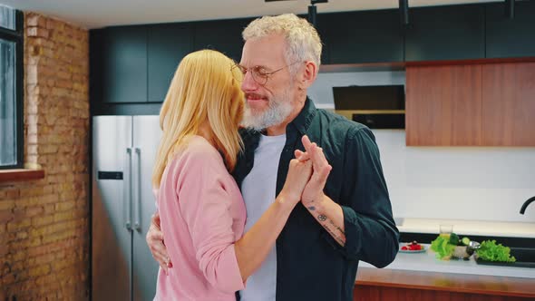 Happy Mature Couple Dancing in Kitchen