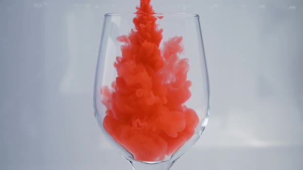 Red Clouds of Paint or Silky Smoke in Wine Glass
