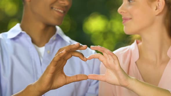 Happy Teenage Couple Making Heart Sing With Fingers, True Love and Relationships