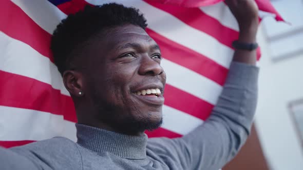 Black Man Waving USA Flag From the Balcony