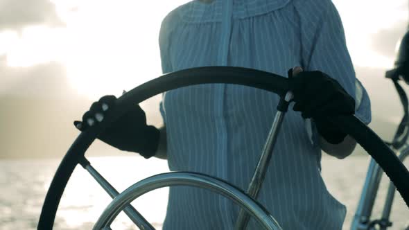 Woman Holds a Helm While Sailing on a Yacht