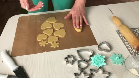 A Woman Works With A Snowflake And Heart Shaped Cookie Dough.
