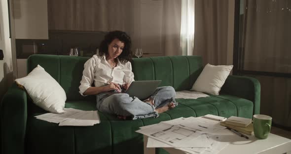 Female Architect Using Laptop on Sofa